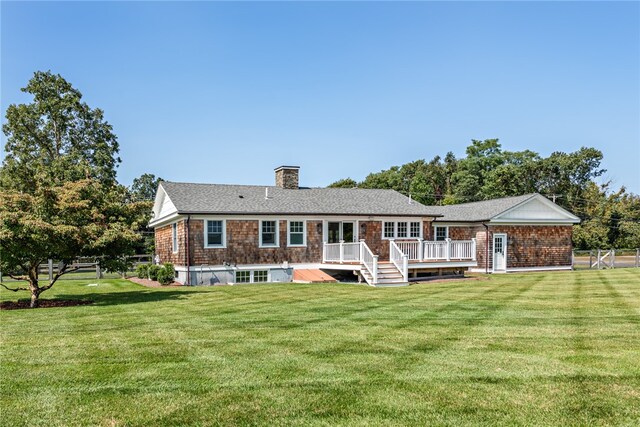 back of house featuring a deck and a yard