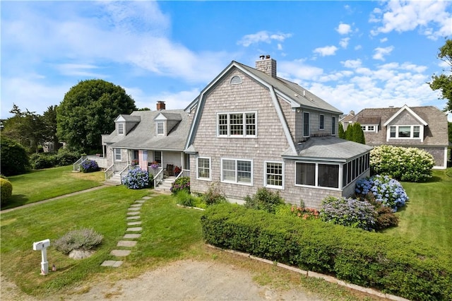 rear view of property with a yard and a sunroom