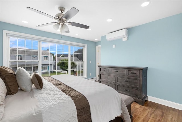 bedroom with ceiling fan, wood-type flooring, an AC wall unit, and multiple windows