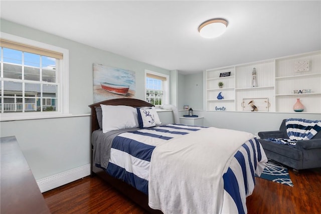 bedroom with dark hardwood / wood-style flooring and a baseboard heating unit