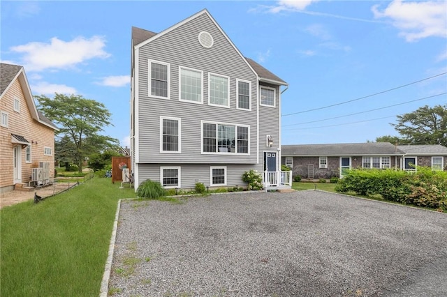 view of front facade with ac unit and a front lawn