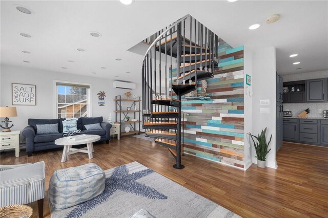 staircase with hardwood / wood-style floors and a wall mounted AC