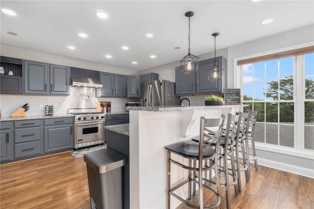 kitchen featuring light wood-type flooring, stainless steel appliances, and gray cabinets