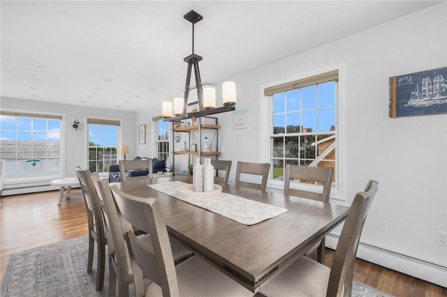 dining space featuring hardwood / wood-style flooring, a notable chandelier, and a baseboard radiator