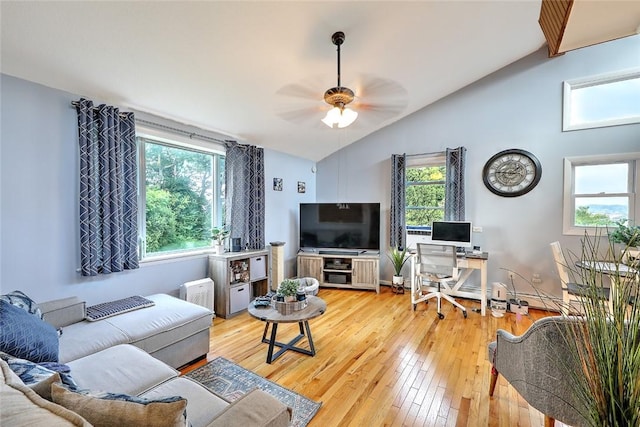 living room with hardwood / wood-style flooring, ceiling fan, and vaulted ceiling