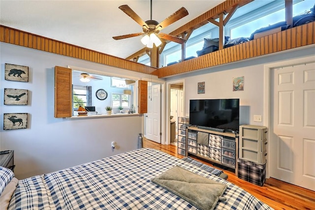 bedroom with ceiling fan, light hardwood / wood-style flooring, and lofted ceiling