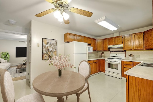 kitchen featuring sink, white appliances, a baseboard radiator, and backsplash