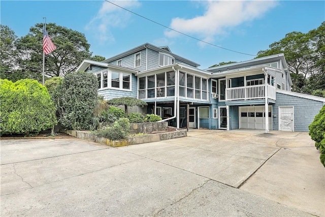 rear view of house featuring a sunroom and a garage