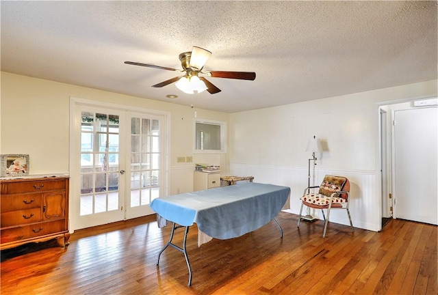 dining area with french doors, a textured ceiling, ceiling fan, and hardwood / wood-style flooring