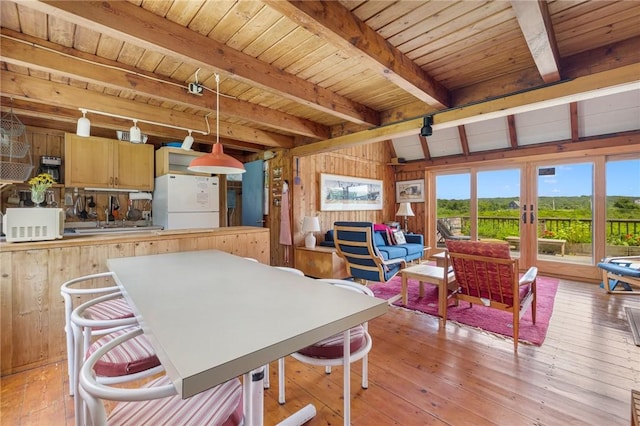 681 Corn Neck Rd, Block Island, RI 02807 - dining area with french doors, wood walls, a wood ceiling with exposed beams, and light wood finished floors
