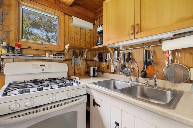 681 Corn Neck Rd, Block Island, RI 02807 - kitchen with white range with gas stovetop, light countertops, wood walls, and white cabinets