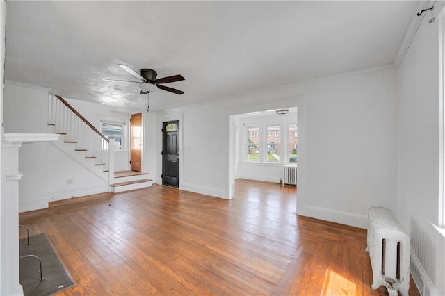 unfurnished living room featuring ceiling fan, radiator, and wood-type flooring