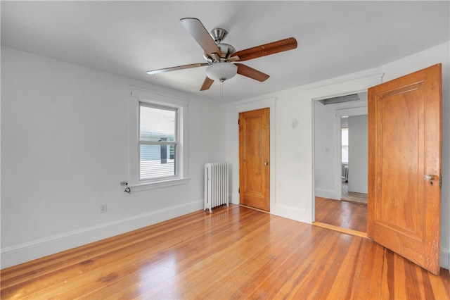 unfurnished bedroom with radiator heating unit, wood-type flooring, and ceiling fan