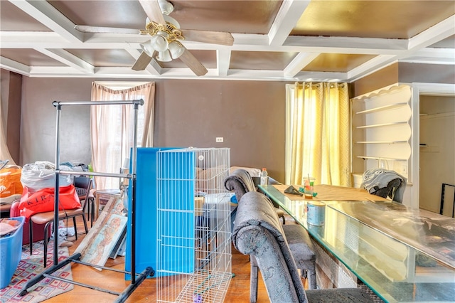 interior space with ceiling fan, coffered ceiling, beamed ceiling, and hardwood / wood-style floors