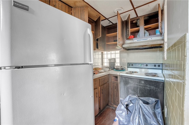 kitchen with dark wood-type flooring, tasteful backsplash, and white appliances