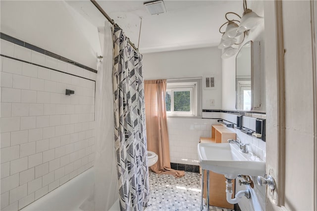 bathroom with toilet, tile walls, backsplash, tile patterned flooring, and shower / bath combo with shower curtain