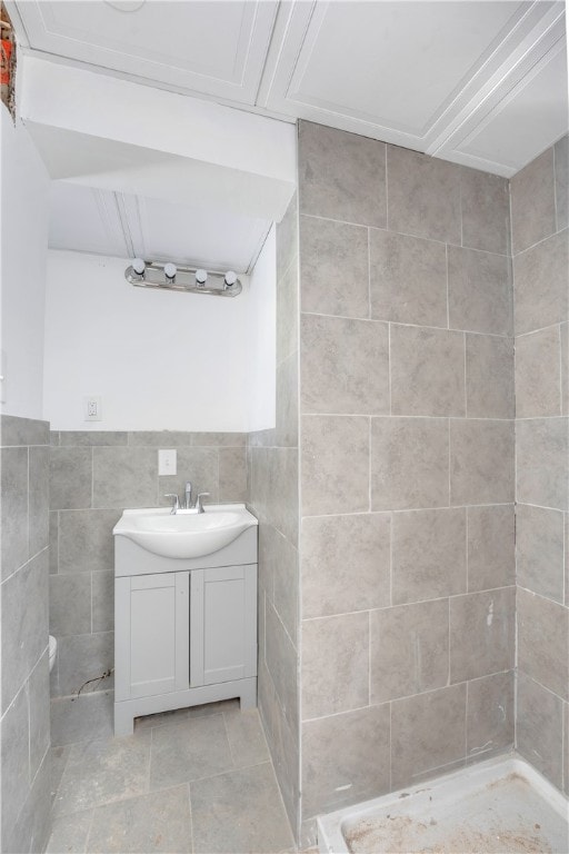 bathroom featuring tile walls, walk in shower, tile patterned floors, and vanity