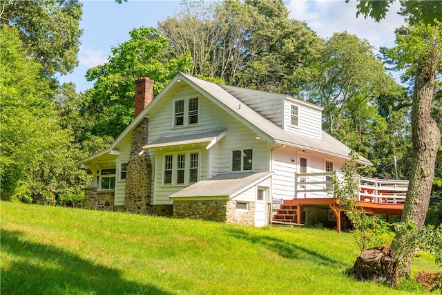 rear view of house with a deck and a lawn