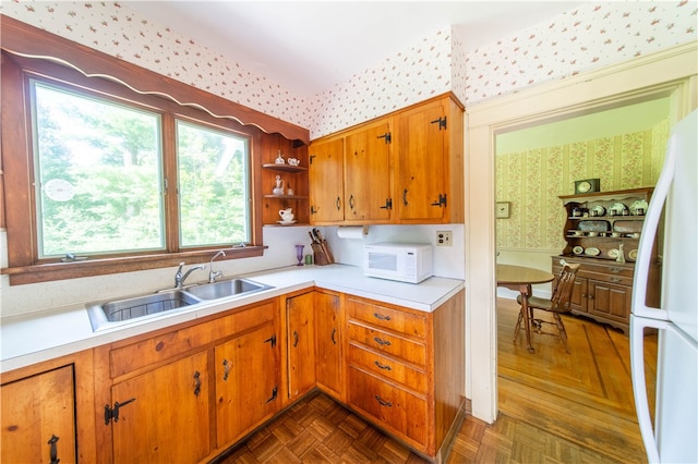 kitchen featuring sink, white appliances, and dark parquet floors