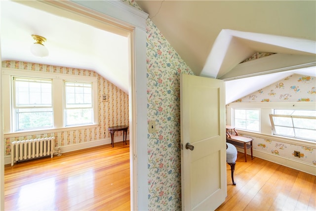 bonus room featuring light hardwood / wood-style floors, lofted ceiling, and radiator