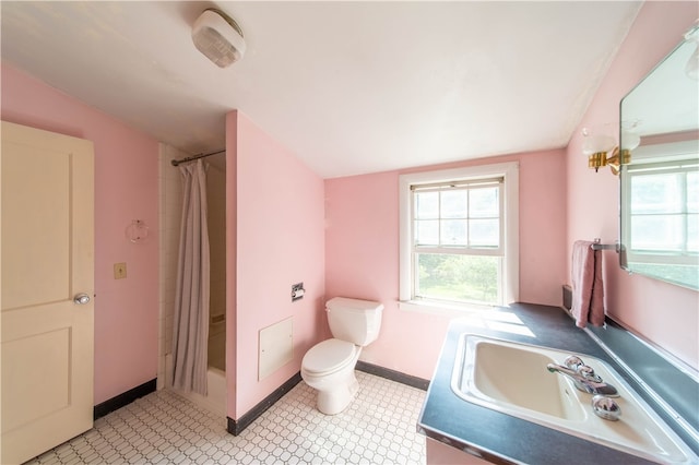 bathroom with vanity, tile patterned flooring, lofted ceiling, and toilet