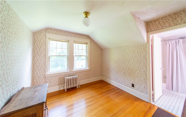 bonus room featuring hardwood / wood-style floors, lofted ceiling, and radiator