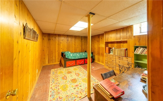 bedroom with wood walls and a drop ceiling