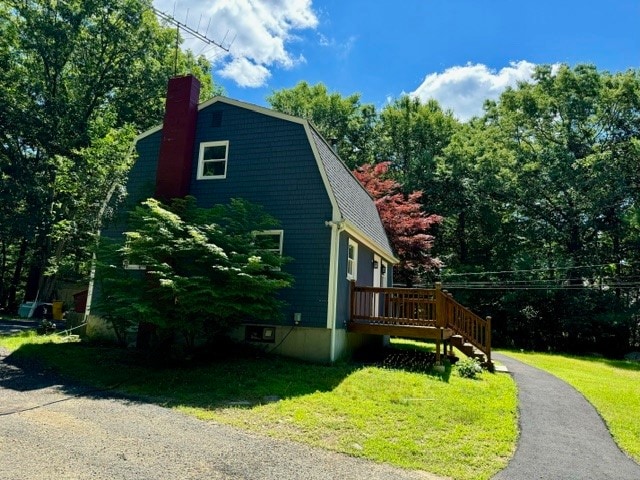 view of side of home with a yard and a wooden deck