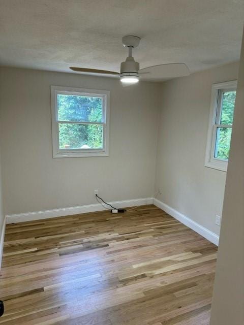 empty room with light hardwood / wood-style floors and ceiling fan