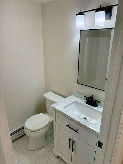 bathroom with vanity, toilet, and a baseboard heating unit