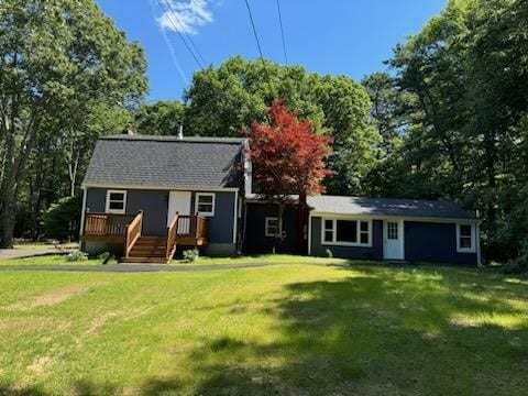 back of house with a deck and a lawn