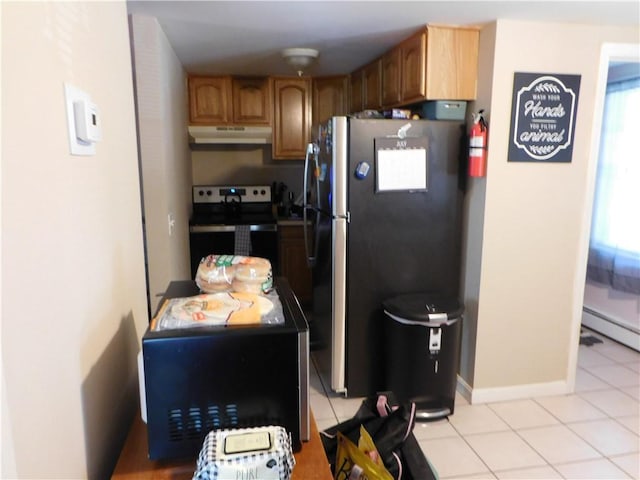 kitchen with light tile patterned flooring, baseboard heating, and stainless steel appliances