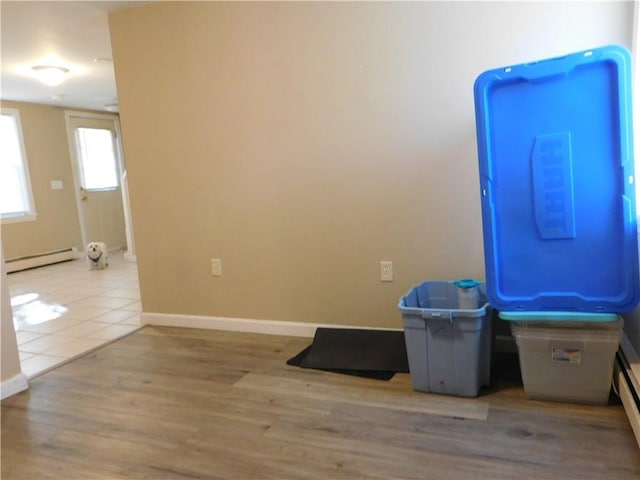 misc room featuring a baseboard heating unit and light wood-type flooring