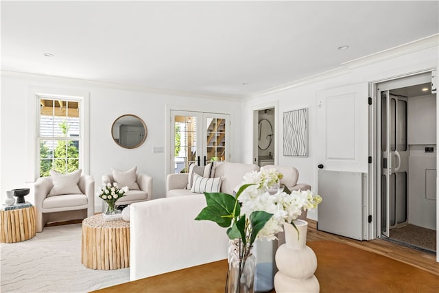 living room with a wealth of natural light, crown molding, wood-type flooring, and french doors