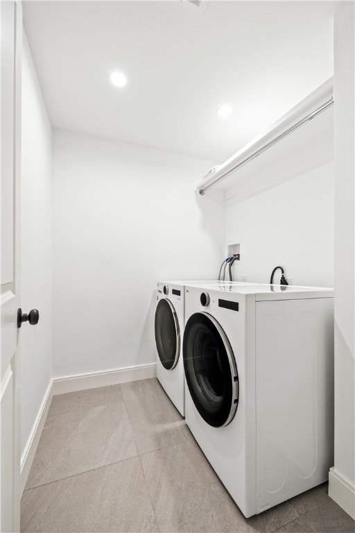 clothes washing area with washer and clothes dryer and light tile patterned floors