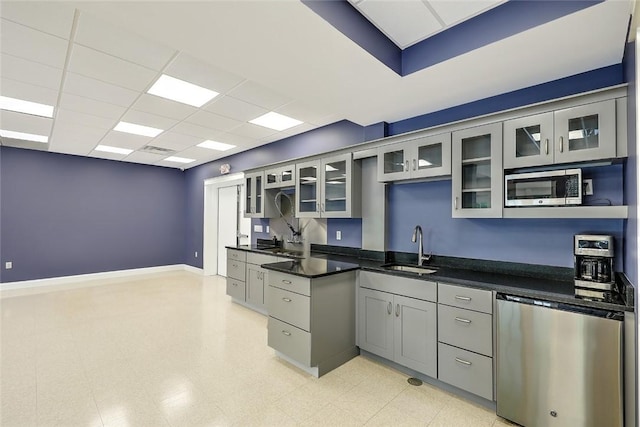 kitchen with stainless steel appliances, sink, a paneled ceiling, and gray cabinetry