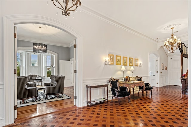 entrance foyer with a notable chandelier, ornamental molding, and parquet floors