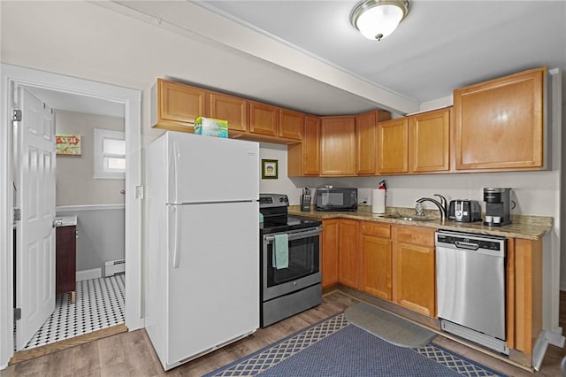 kitchen with appliances with stainless steel finishes, sink, light hardwood / wood-style floors, and baseboard heating