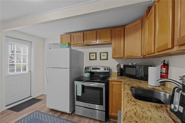 kitchen featuring sink, light stone counters, light hardwood / wood-style floors, stainless steel range with electric cooktop, and white fridge