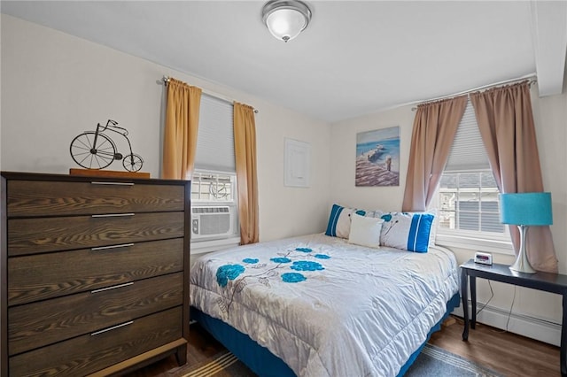 bedroom with cooling unit, a baseboard radiator, and dark hardwood / wood-style flooring