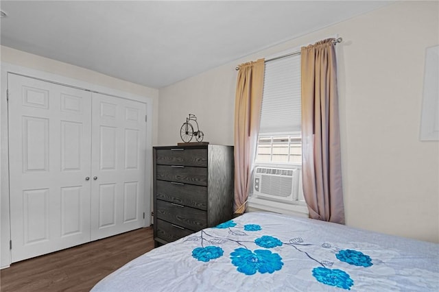 bedroom with dark hardwood / wood-style floors, cooling unit, and a closet