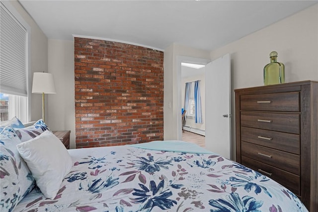 bedroom with brick wall and baseboard heating