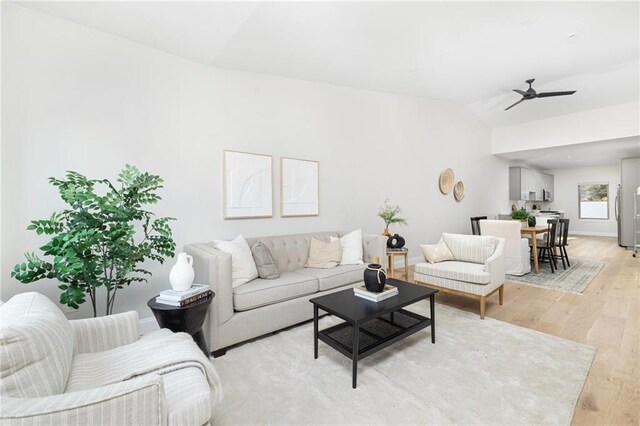 living room with lofted ceiling, light hardwood / wood-style floors, and ceiling fan