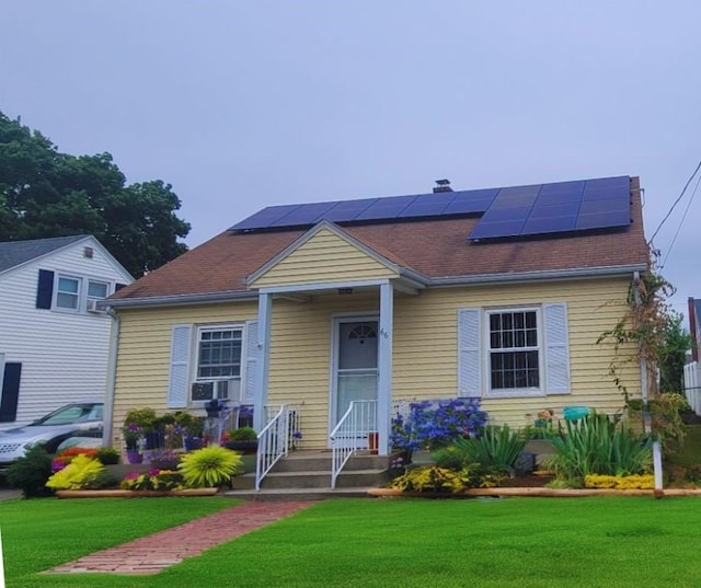 view of front facade with a front yard and solar panels