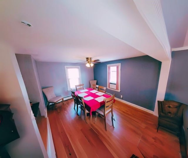 dining room with hardwood / wood-style floors, a baseboard radiator, and ceiling fan