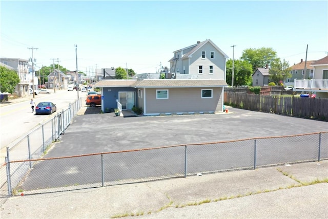 view of front of house with a residential view and fence