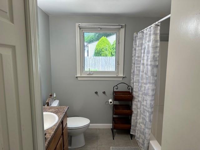 full bathroom featuring tile patterned floors, shower / bathtub combination with curtain, toilet, and vanity