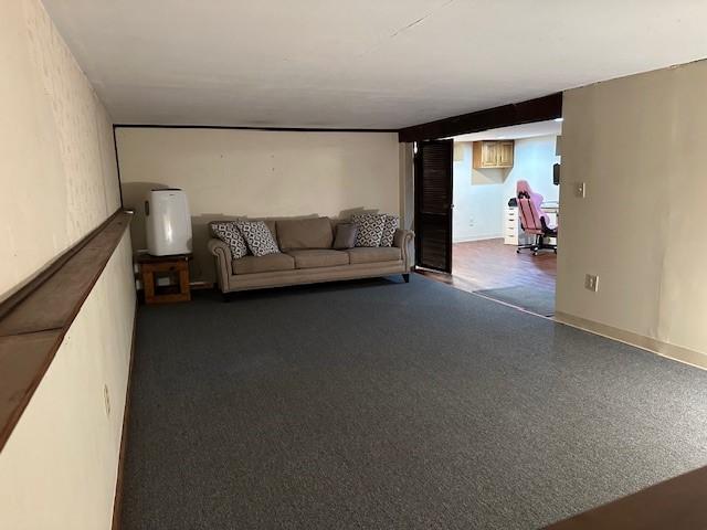 unfurnished living room featuring dark colored carpet