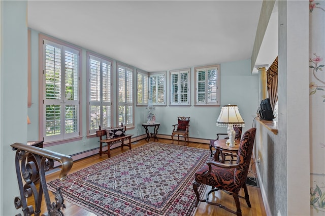 interior space with light hardwood / wood-style flooring, decorative columns, and plenty of natural light