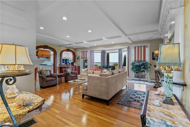 living room featuring coffered ceiling, beamed ceiling, and light hardwood / wood-style flooring